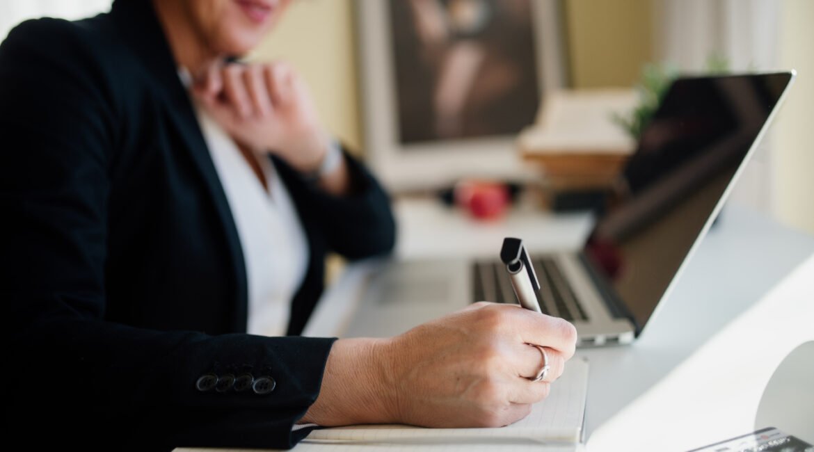 Profissional analisando documentos e notebook em escritório, representando compliance trabalhista