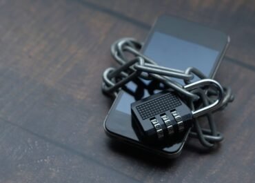 Celular envolvido por uma corrente e um cadeado, simbolizando a proteção de dados pessoais