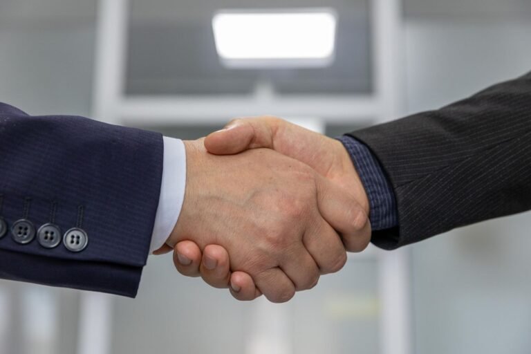 Aperto de mãos entre dois executivos, simbolizando confiança e credibilidade da reputação empresarial